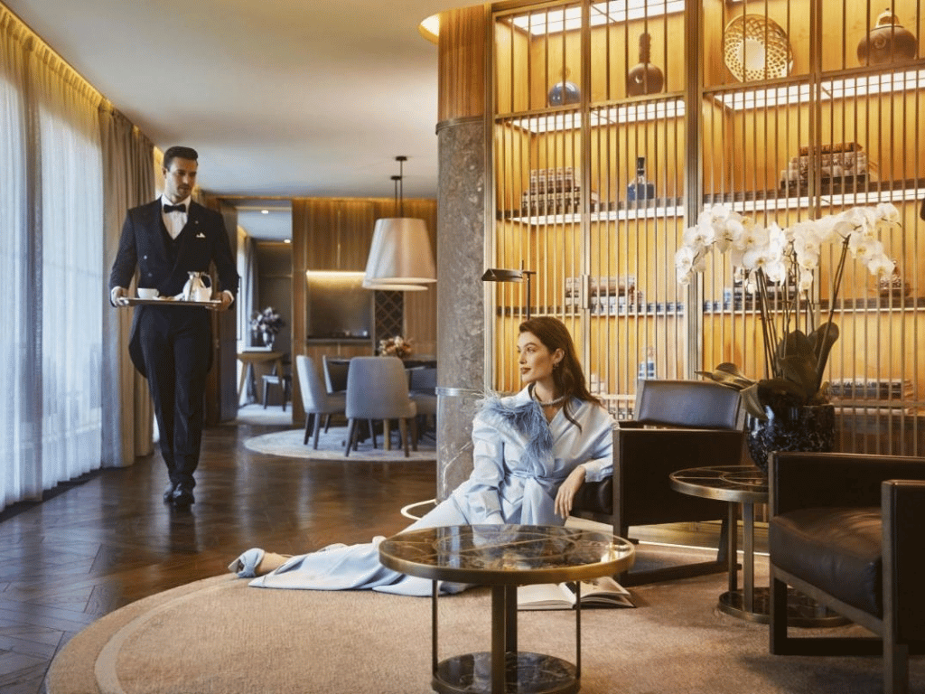 Luxury hotel hospitality experience with a waiter serving a guest in an elegant lounge